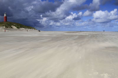 Eierland lighthouse at beach against sky