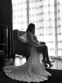 Pregnant woman sitting on chair at home