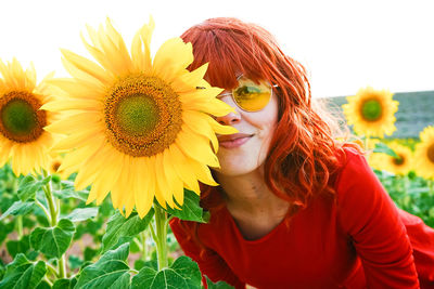 Portrait of beautiful young woman with sunflower