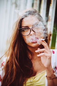 Portrait of woman smoking cigarette outdoors