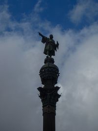 Low angle view of angel statue against cloudy sky