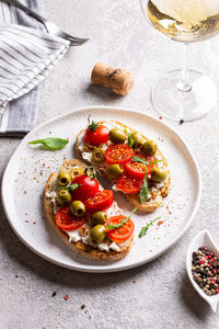 Plate with bruschettas and glass of wine