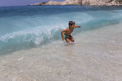 Little kid enjoying the waves on the beach