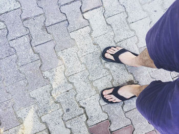 Low section of man standing on footpath