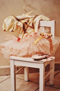 Close-up of dress with ballet shoes on chair