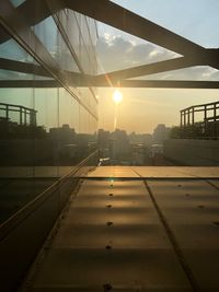 Railroad tracks in city against sky during sunset