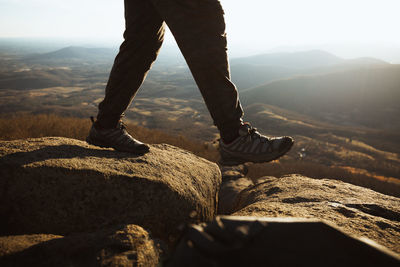 Low section of man standing on rock