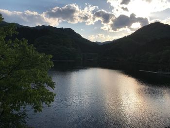 Scenic view of lake by mountains against sky