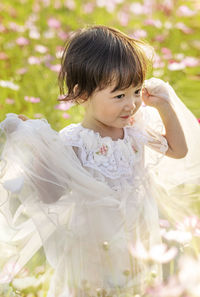 Portrait of cute girl standing against plants