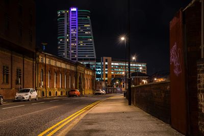 Illuminated city street and buildings at night