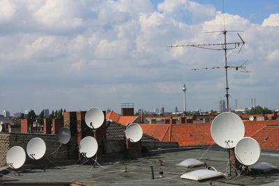 Aerial view of satellite receivers against sky and tv tower