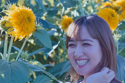 Portrait of smiling young woman with yellow flowering plants