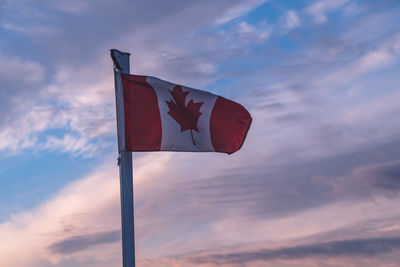 Low angle view of canadian flag against sky during sunset