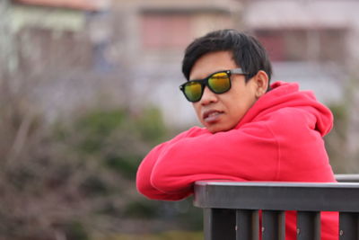 Man looking away while sitting on bench