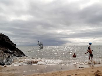 People on beach against sky