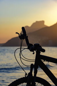 Bicycle silhouette  on ipanema beach at sunset