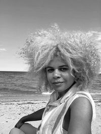 Portrait of beautiful woman at beach against sky