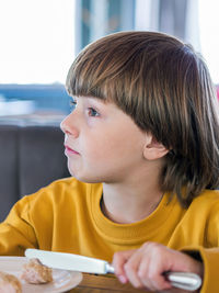 Close-up of boy eating food at cafe