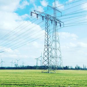 Electricity pylon on field against sky