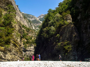 People walking on rocks against mountains