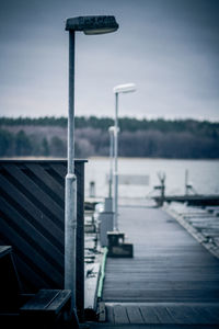Street light by lake against sky