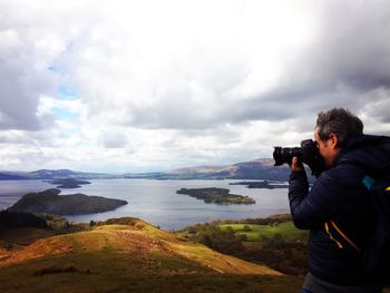 Man photographing sea from on camera