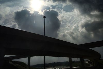 Low angle view of bridge against cloudy sky