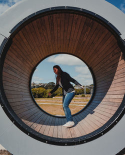 Full length of woman standing on circular structure