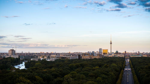 Fernsehturm and cityscape by tiergarten against sky