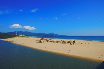 Scenic view of beach against blue sky