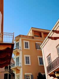 Low angle view of buildings against clear blue sky