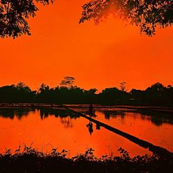 Scenic view of lake against orange sky