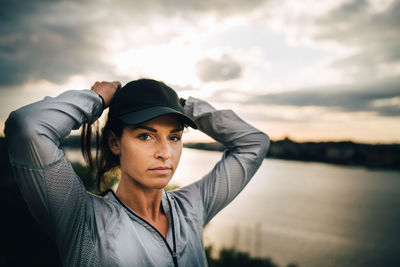 Portrait of young woman looking away against sky