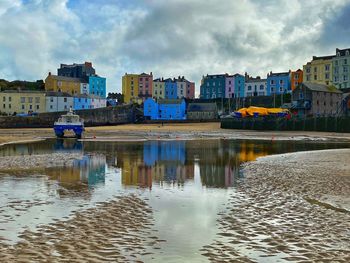 Tenby harbour with houses reflected in the pool of water.