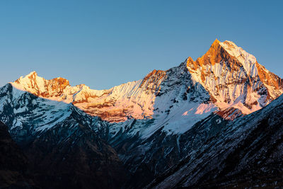 Scenic view of snowcapped mountains against clear blue sky