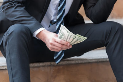 Midsection of man sitting on table