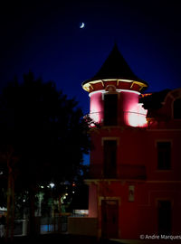 Low angle view of illuminated building against sky at night