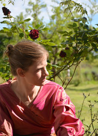 Close-up of young woman with flowers on tree