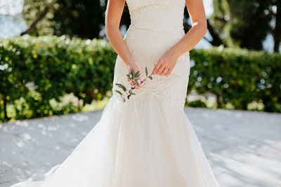 Midsection of bride standing in park