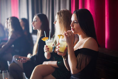 Side view of friends sitting at restaurant