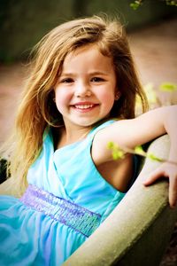 Portrait of smiling cute girl sitting outdoors