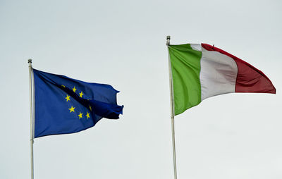 Low angle view of flags against clear sky