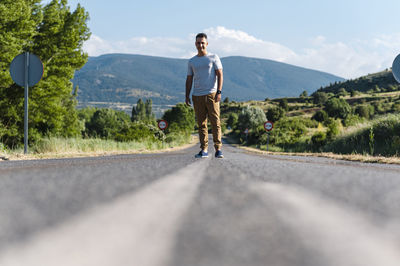 Full length of man standing on road against sky