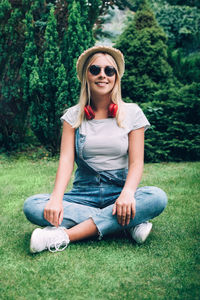 Portrait of a smiling young woman sitting on grass