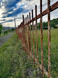 Wooden posts in field against sky