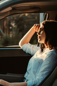 Side view of woman sitting in car