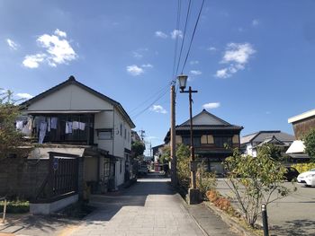 Houses by street against sky in city