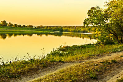 Scenic view of lake against sky at sunset