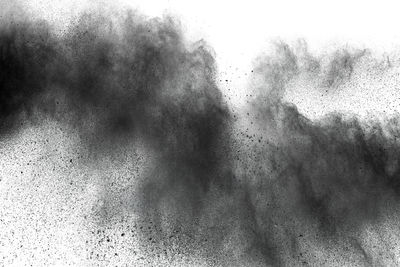 Defocused image of black powder paints against white background