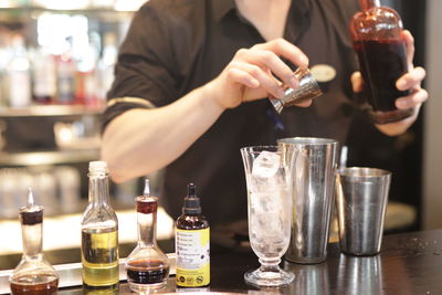 Midsection of man pouring wine in glass